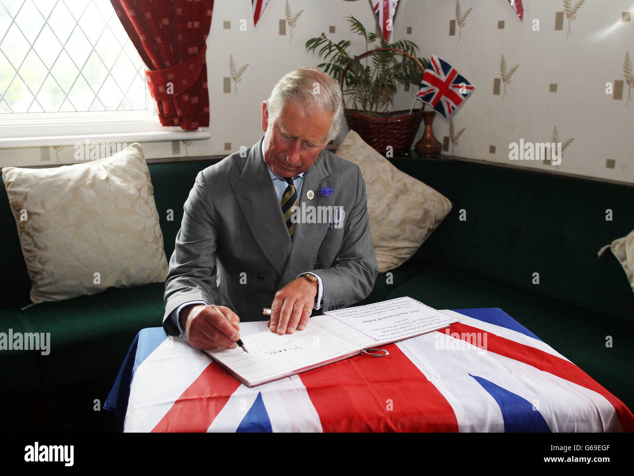 Der Prinz von Wales signiert das Gästebuch im Burton Arms Pub während eines Spaziergangs in Burton Fleming, East Yorkshire. Stockfoto