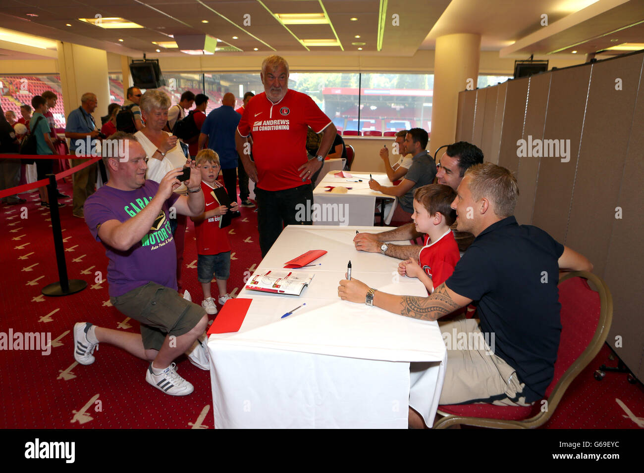 Andy Hughes und Chris Solly (rechts) von Charlton Athletic posieren während einer Signiersitzung für ein Bild mit jungen Fans Stockfoto