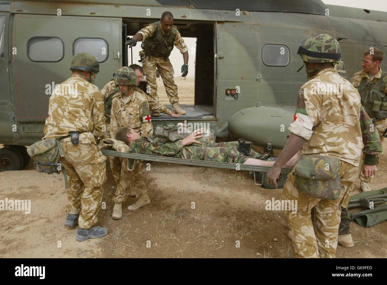Ein britischer Soldat hält sich an seinen Helm, als er von der 33 Squadron Pumas aus einer operierenden Basis im Südirak medizinisch evakuiert wird, in ein Feldlazarett, um sich mit einer Beinverletzung zu befassen. Stockfoto
