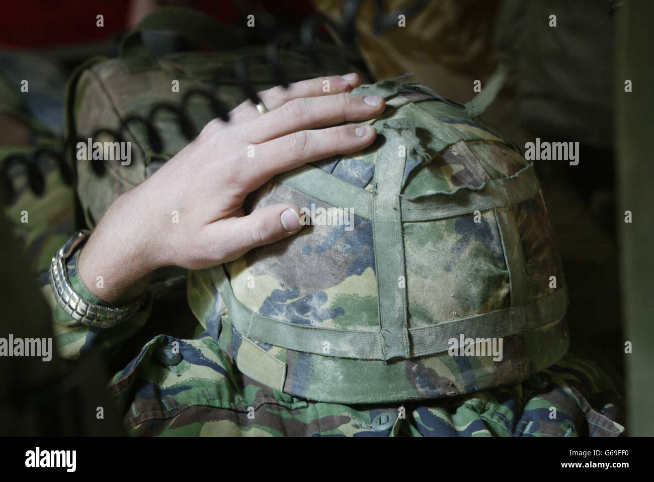 Ein britischer Soldat hält sich an seinen Helm, als er von der 33 Squadron Pumas aus einer operierenden Basis im Südirak medizinisch evakuiert wird, in ein Feldlazarett, um sich mit einer Beinverletzung zu befassen. Stockfoto