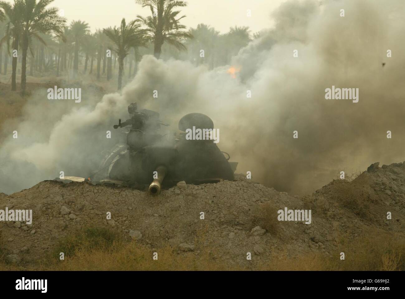 Irakische Milizen kapitulieren als russischer T-55-Panzer schwelt im Hintergrund, als 40 Royal Marines des Kommandos in Abu Al Khasib, einem Vorort von Basra im südlichen Irak, einziehen. Stockfoto