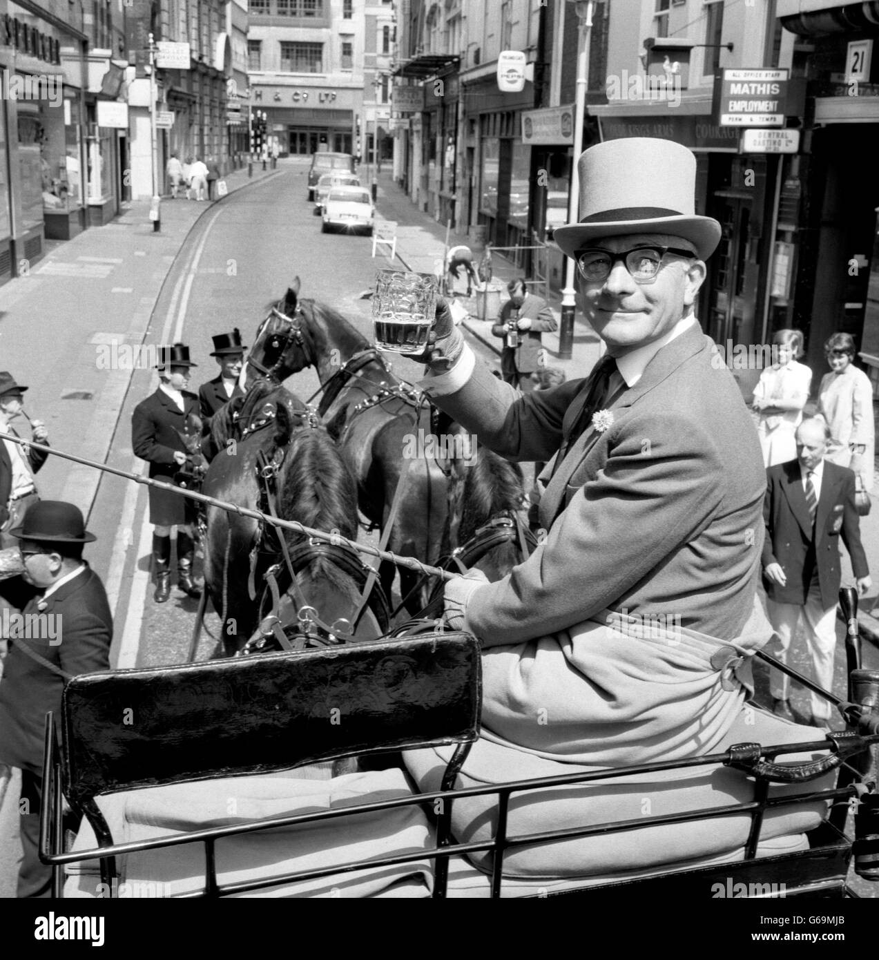 Generalmajor Errol H G Lonsdale, der Chief Transportoffizier der Armee, hebt einen Tanker im Fahrersitz des Reisebusses des Royal Corps of Transport und der vier. Er hatte gerade den Bus durch die Straßen von Regent's Park Barracks, Albany Street, zum öffentlichen Haus Coach and Horses, Great Marlborough Street, gefahren, das heute bei einer Zeremonie vom Royal Army Service Corps und der Royal Corps of Transport Association angenommen wurde. Die Annahme erfolgte, weil die Vereinigung der Ansicht war, dass es in London ein zentrales Treffen geben sollte, bei dem sich jedes ihrer 16,000 Mitglieder einigermaßen sicher sein könnte Stockfoto