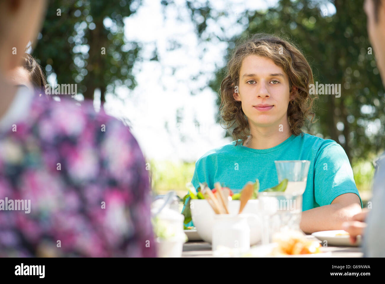 Junger Mann im Freien essen mit Freunden Stockfoto
