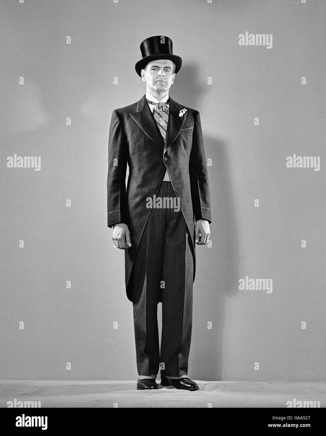 1940S 1950S IN VOLLER LÄNGE PORTRAIT BRÄUTIGAM BRÄUTIGAM TRAGEN FORMALEN STRESEMANN ZYLINDERHUT ASCOT ERNSTEN GESICHTSAUSDRUCK Stockfoto