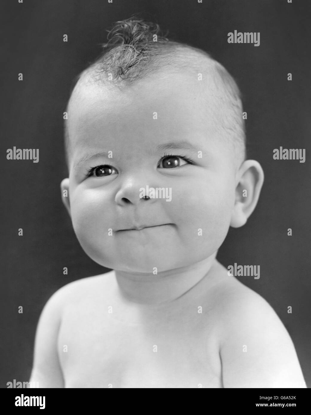 1940S 1950S BABY PORTRAIT NATURHAAR MOHAWK LÄCHELND BLICK IN DIE KAMERA, DIE NIEDLICHEN LIEBENSWERT Stockfoto