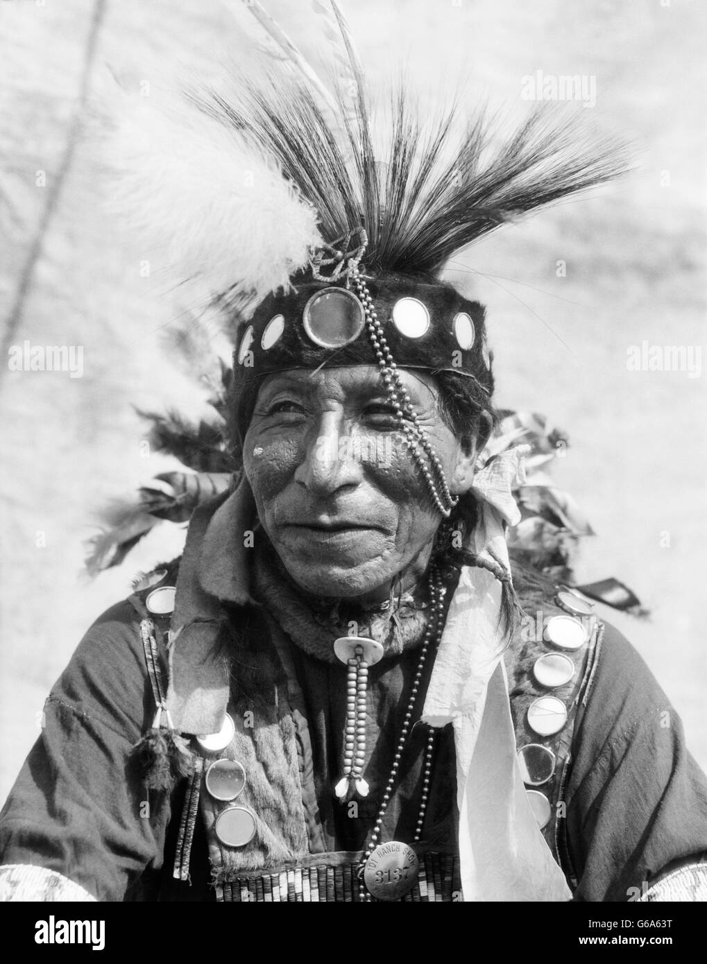 1920ER JAHRE PORTRAIT INDIANISCHEN MANN VON CHEROKEE STAMM SHIRT MIT KLEINEN SPIEGELN VERZIERT Stockfoto