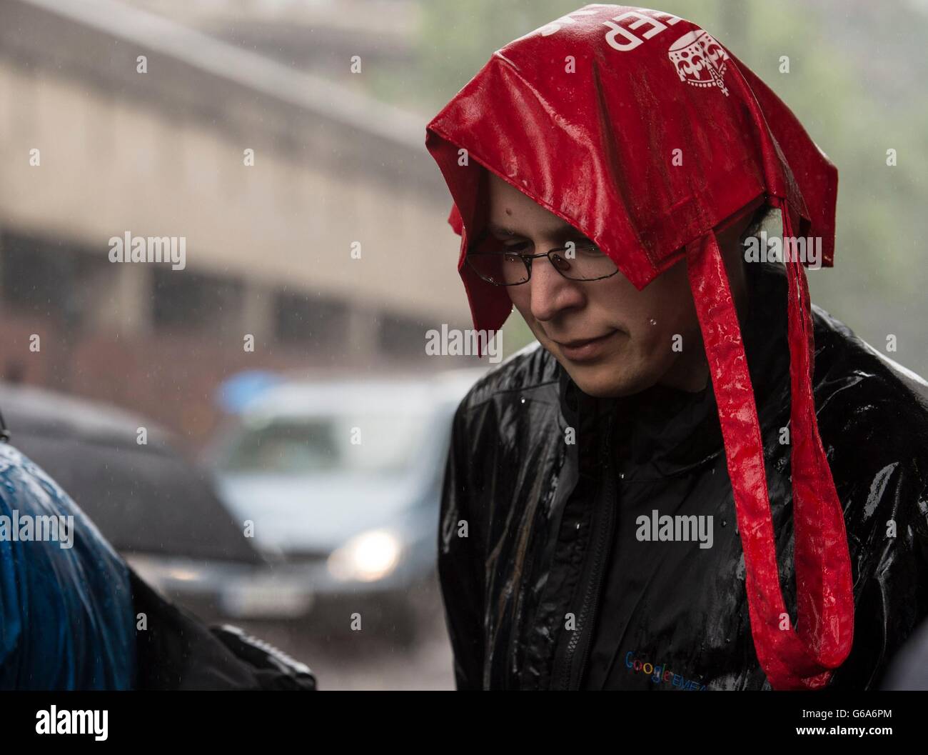 Menschen bekommen in einem Regenschauer in der Nähe in der Londoner Barbican gefangen. Stockfoto