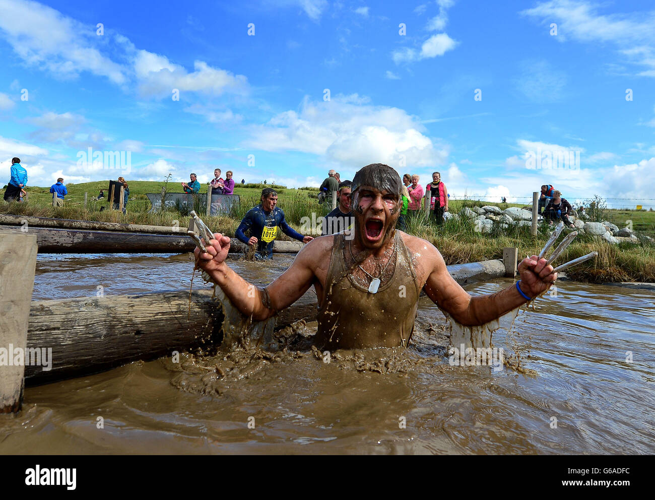 Teilnehmer im Abschnitt „Dunking Time“ der Total Warrior 10 Mile Challenge in Shap Abbey, Cumbria. Stockfoto