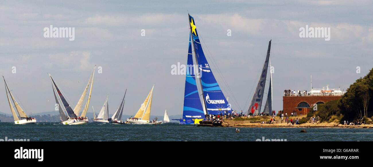 Die hohen Masten der britischen Yacht ICAP Leopard (rechts) und Esimit Europa 2 (blaue Segel) passieren Fort Albert, während sie während des 45. Rolex Fastnet Race auf dem Solent, nahe Cowes, Isle of Wight, aus dem östlichen Solent herausfahren. Stockfoto