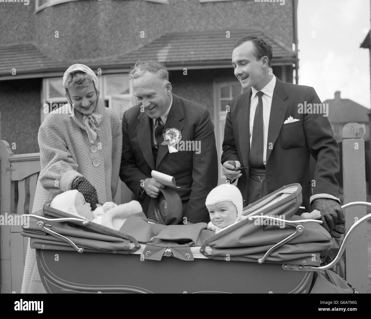 Commander Anthony Courtney (Mitte) trifft Michael und Nigel, einjährige Zwillinge von Mr. Und Mrs. R. Tanby, während er in Harrow East, Middlesex, Bilder zeigt, wo er konservativer Kandidat bei der Nachwahl zum Parlament ist. Stockfoto