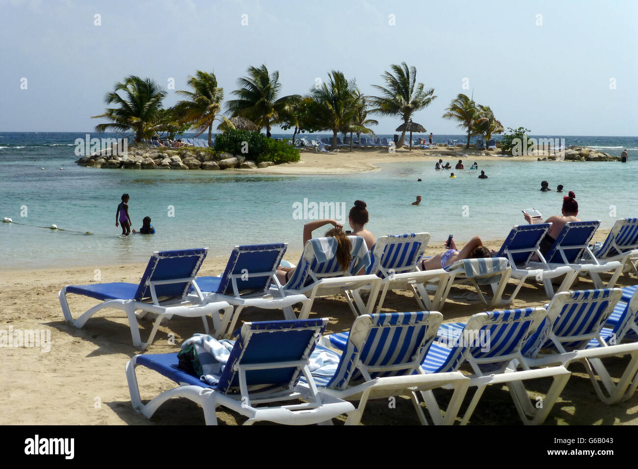 Strand mit Liegestühlen auf goldenen Sand und blaues Meer... blauer Himmel und heißen sonnigen Tag... Kleine Insel in den Hintergrund zu Fuß Stockfoto