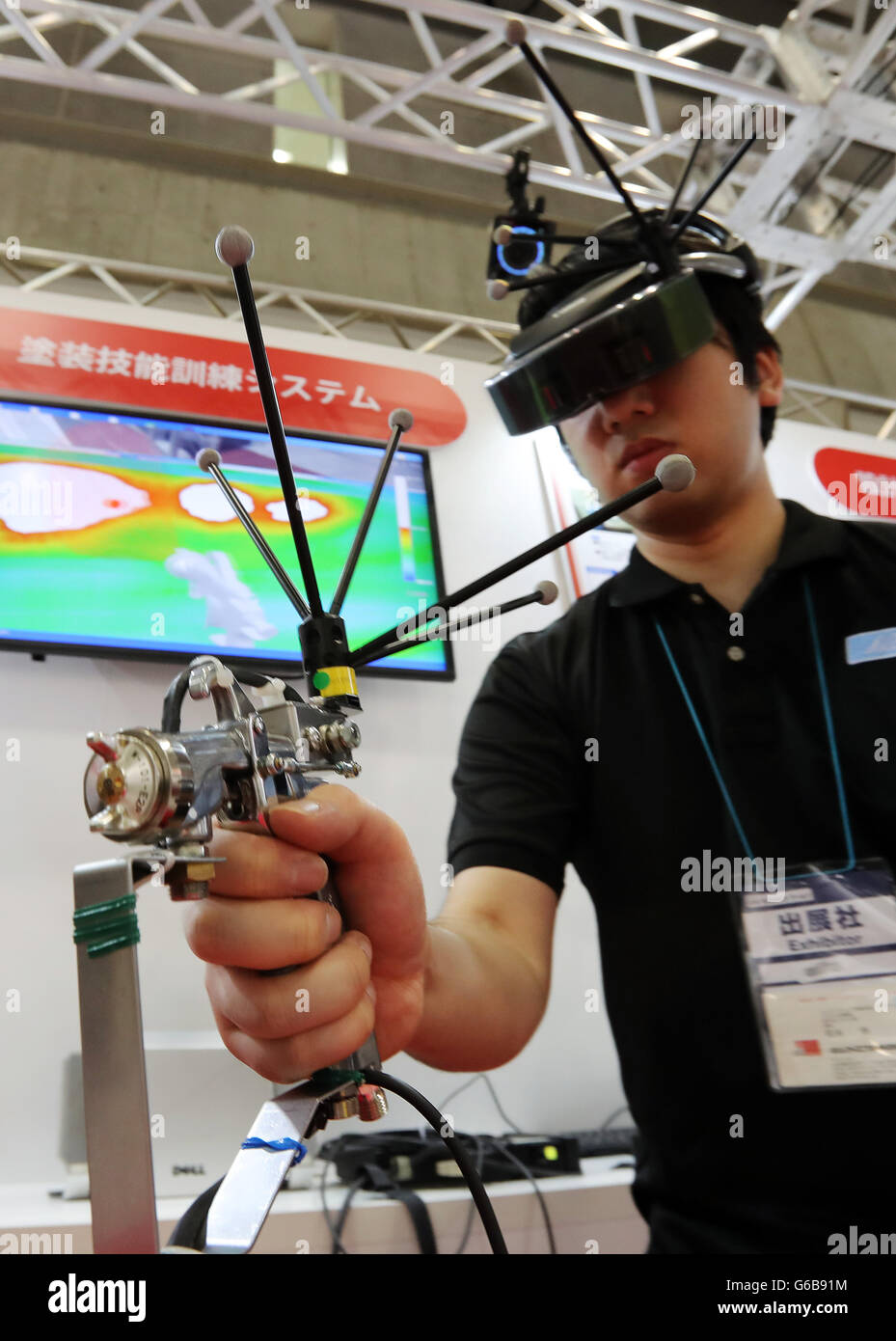 Tokio, Japan. 23. Juni 2016. Ein Mitarbeiter des japanischen Asahi Elektronik zeigt virtuelle Lackieranlage mit Spritzpistole und Canons mixed-Reality Galgen Display (HMD) für die Ausbildung von Malern an der jährlichen virtuelle Realität Expo (IVR) in Tokio auf Donnerstag, 23. Juni 2016. IVR stellte die neueste Technologie der virtuellen Realität und 3D-Bild Produkte. Kredite: Yoshio Tsunoda/AFLO/Alamy Live-Nachrichten Stockfoto