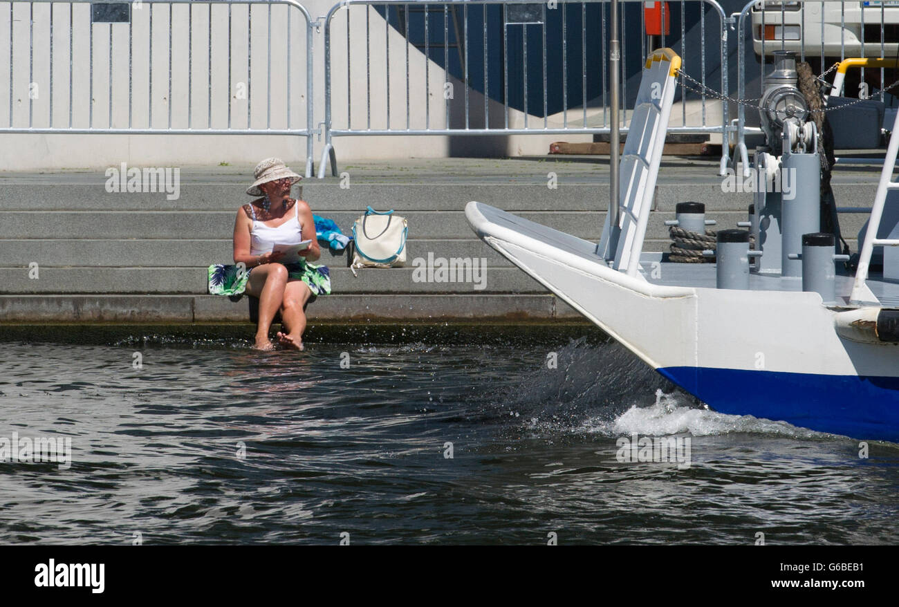 Berlin, Deutschland. 24. Juni 2016. Eine Frau, die ihre Füße in Spree entlang während eines Schiffes Abkühlung geht in Berlin, Deutschland, 24. Juni 2016. Foto: PAUL ZINKEN/Dpa/Alamy Live News Stockfoto