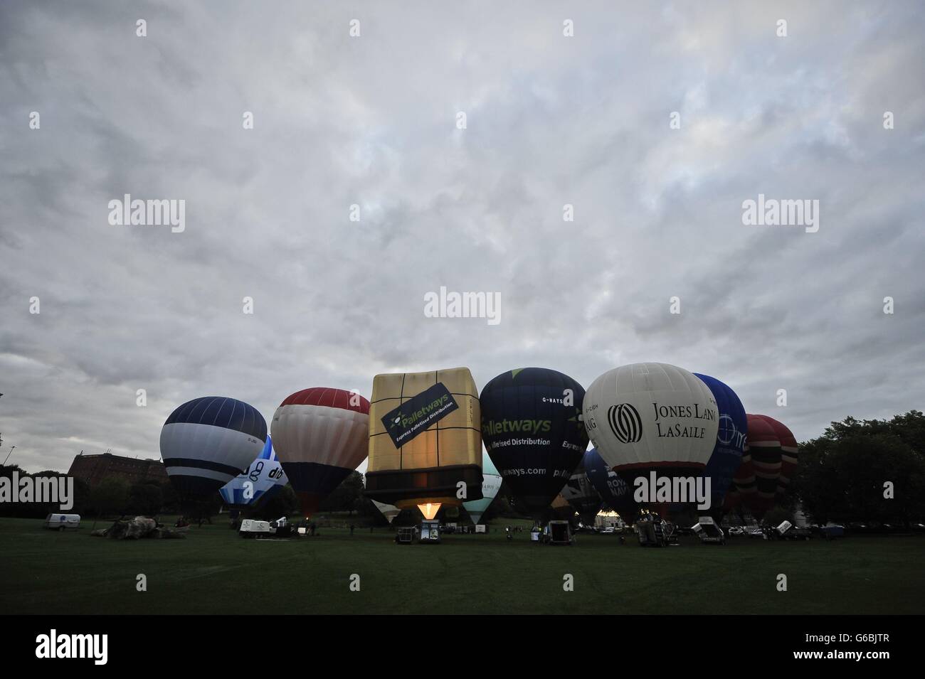 Im Greville Smyth Park, Bristol, werden Heißluftballons aufgeblasen, um sich auf die Bristol International Balloon Fiesta 2013 vorzubereiten, bei der sich Ballonpiloten aus der ganzen Welt zum viertägigen Festival im Ashton Court Estate versammeln werden. Stockfoto
