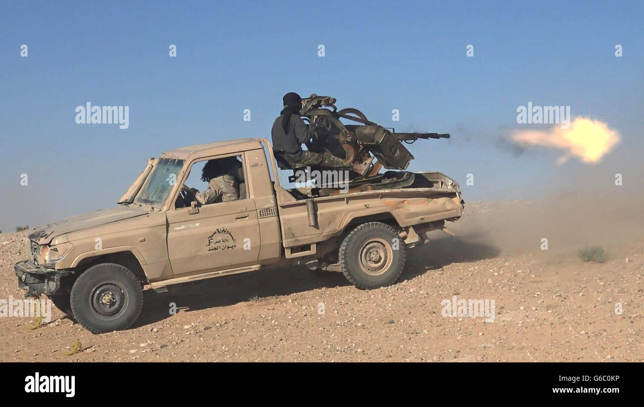 Islamischer Staat Kämpfer verwenden schweren Maschinengewehren Pickup-Truck montiert während des Kampfes gegen syrische Regierungstruppen 20. Juni 2016 in der Nähe von Palmyra, Syrien. Das Standbild wird aus einem Propaganda video veröffentlicht von der islamischen Staates im Irak und der Levante erfasst. Stockfoto