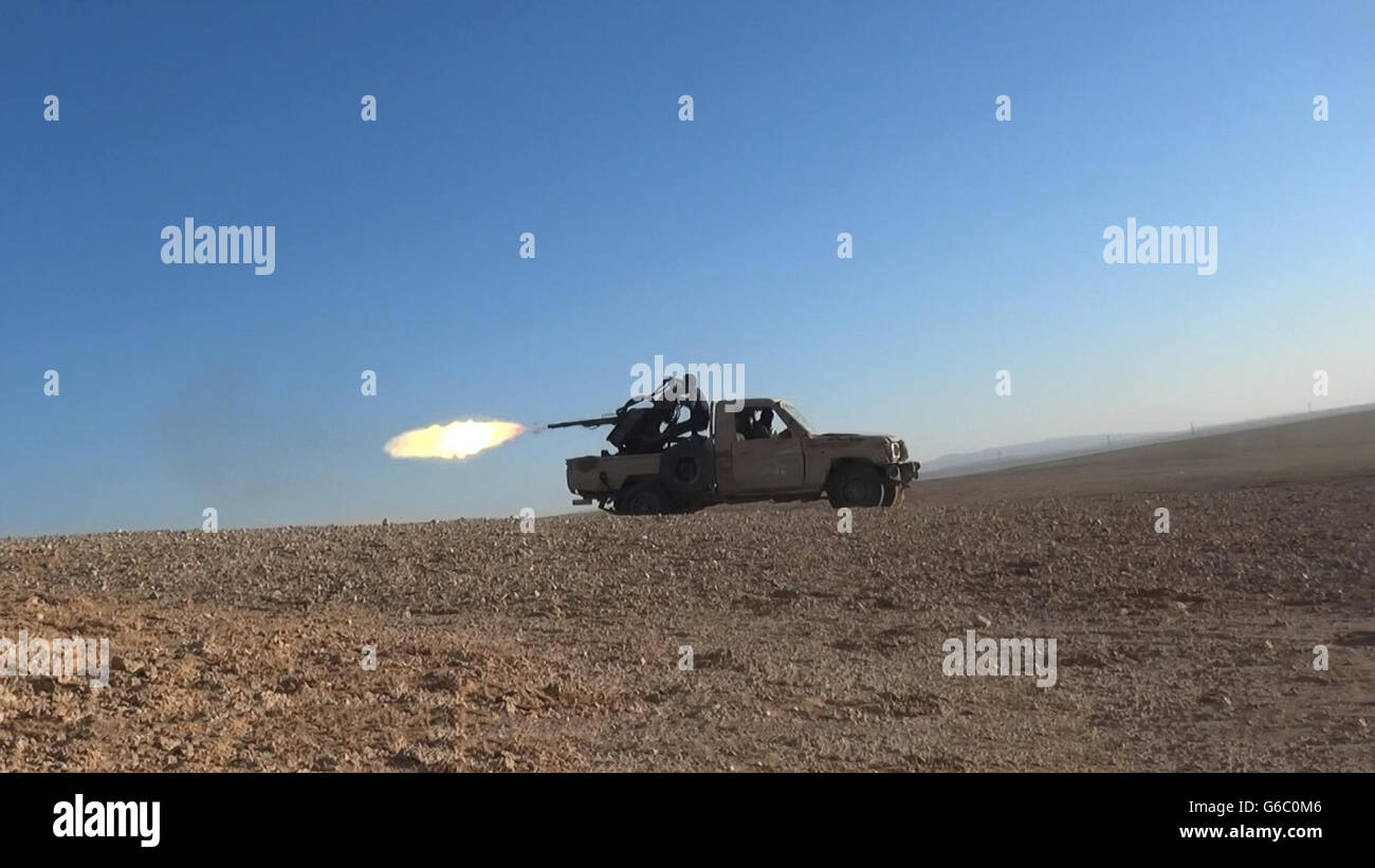 Islamischer Staat Kämpfer verwenden schweren Maschinengewehren Pickup-Truck montiert während des Kampfes gegen syrische Regierungstruppen 20. Juni 2016 in der Nähe von Homs, Syrien. Das Standbild wird aus einem Propaganda video veröffentlicht von der islamischen Staates im Irak und der Levante erfasst. Stockfoto
