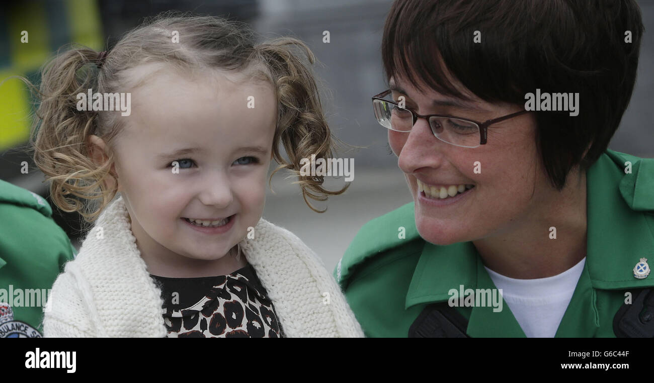 Die dreijährige Casey McLean mit der Julie Grainger, einer der Sanitäter, die ihr Leben rettete, nachdem sie in Glasgow einen Herz-/Atemstillstand erlitten hatte. Stockfoto