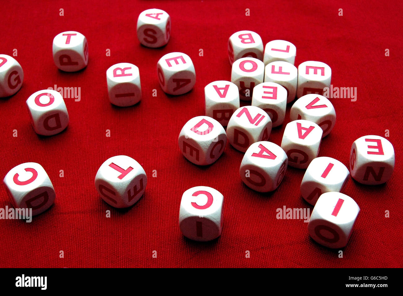 Buchstaben-Würfel auf einem roten Tisch Stockfoto