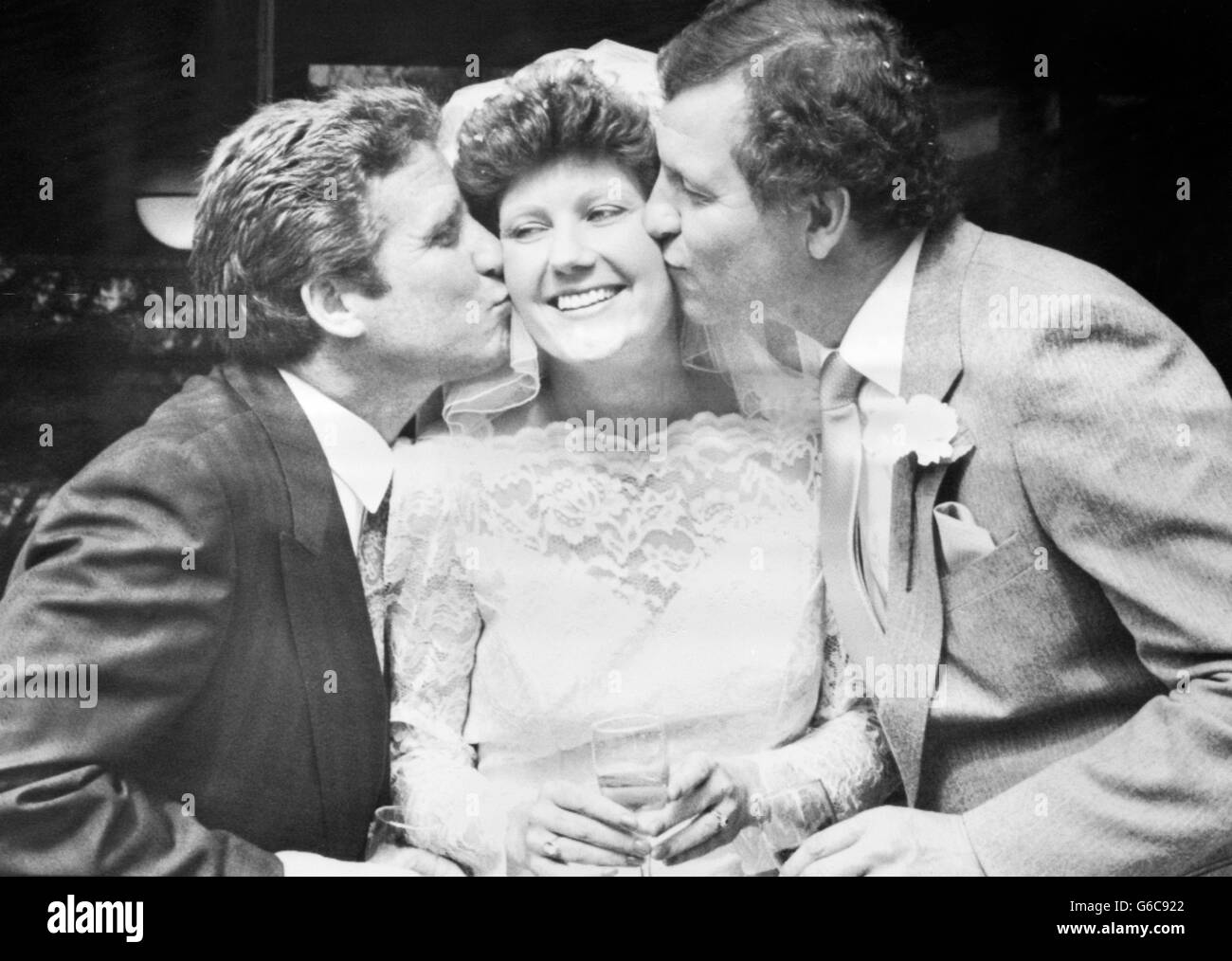 Der ehemalige Chelsea- und England-Fußballspieler Peter Osgood (rechts) küsst seine Braut Lyn Finlay, während sie einen weiteren Kuss vom Portsmouth FC-Manager Alan Ball erhält. Osgood, derzeit Manager des Jugendteams von Portsmouth, heiratete Lyn in einem Standesamt in Fareham, Hampshire. Stockfoto