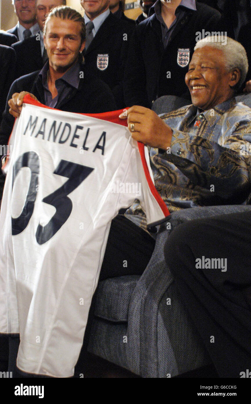 Fußball - Freundschaftsspiel - Südafrika gegen England - Durban. Der ehemalige Präsident Nelson Mandela erhält in Johannesburg von Kapitän David Beckham ein England-Trikot mit „Mandela“ auf dem Rücken. Stockfoto