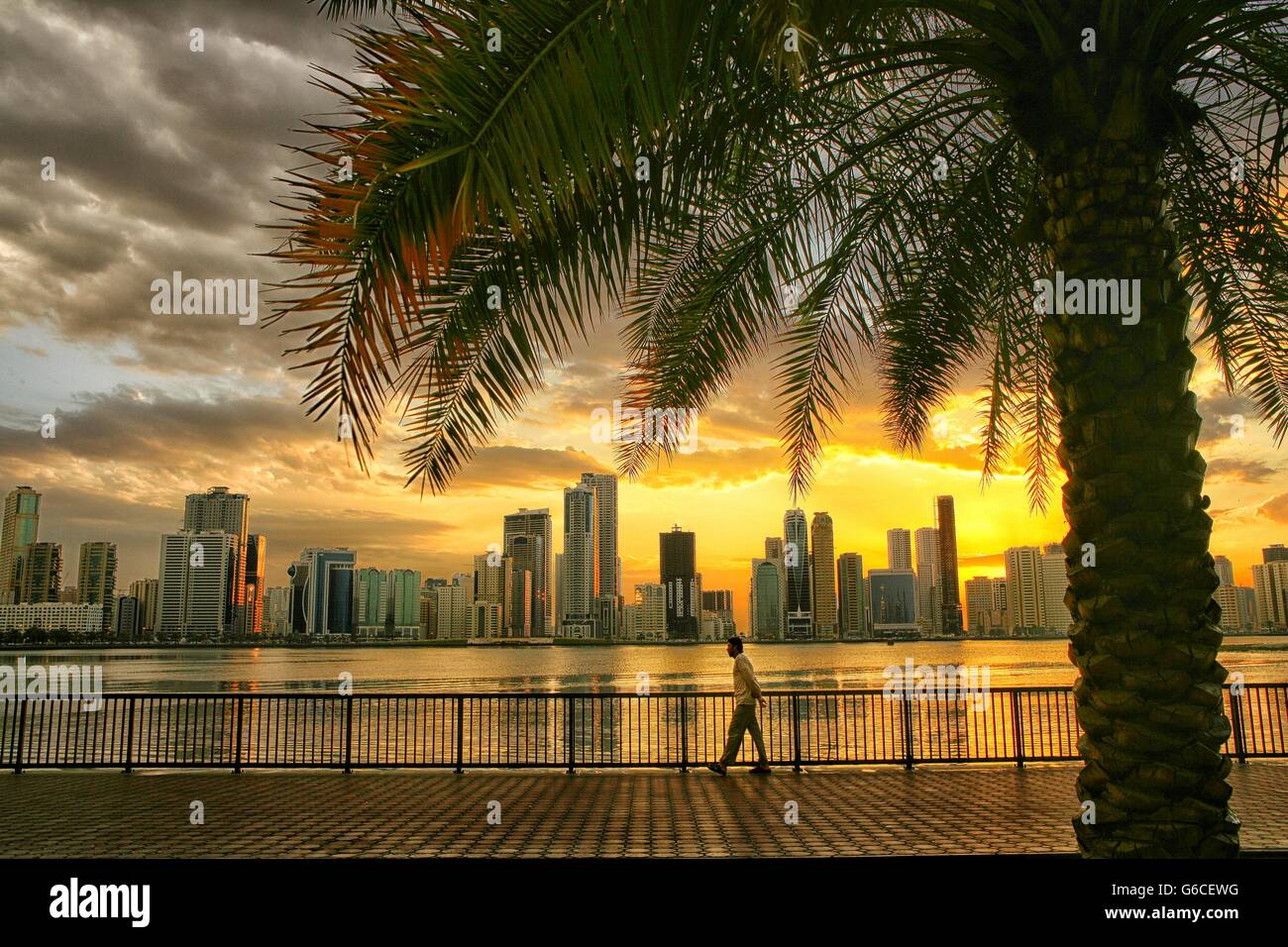 Gebäude vor Himmel mit ruhigen Fluss im Vordergrund bei Sonnenuntergang Stockfoto