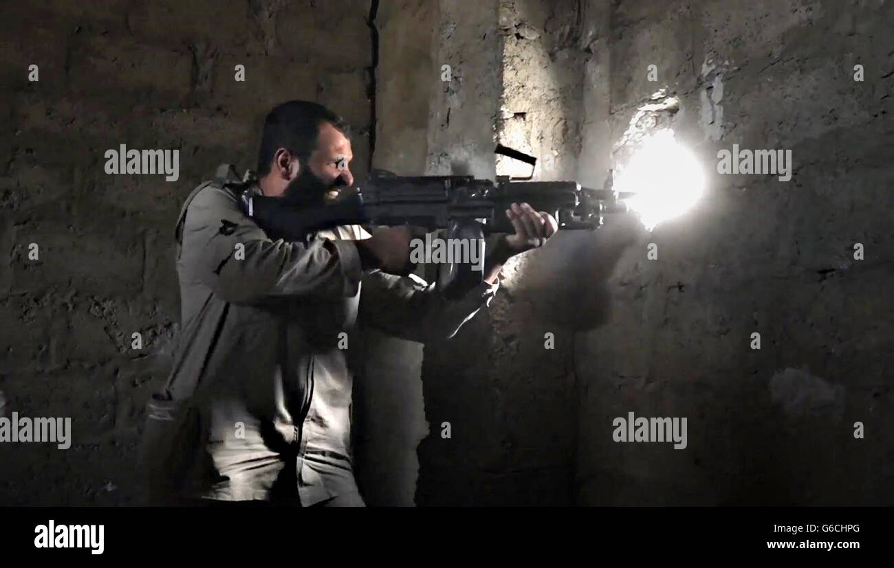 Islamischer Staat Kämpfer Brände eine automatische Waffe im städtischen Kampf 4. April 2016 in der Nähe von Zawbaa, Irak. Das Standbild wird aus einem Propaganda video veröffentlicht von der islamischen Staates im Irak und der Levante erfasst. Stockfoto