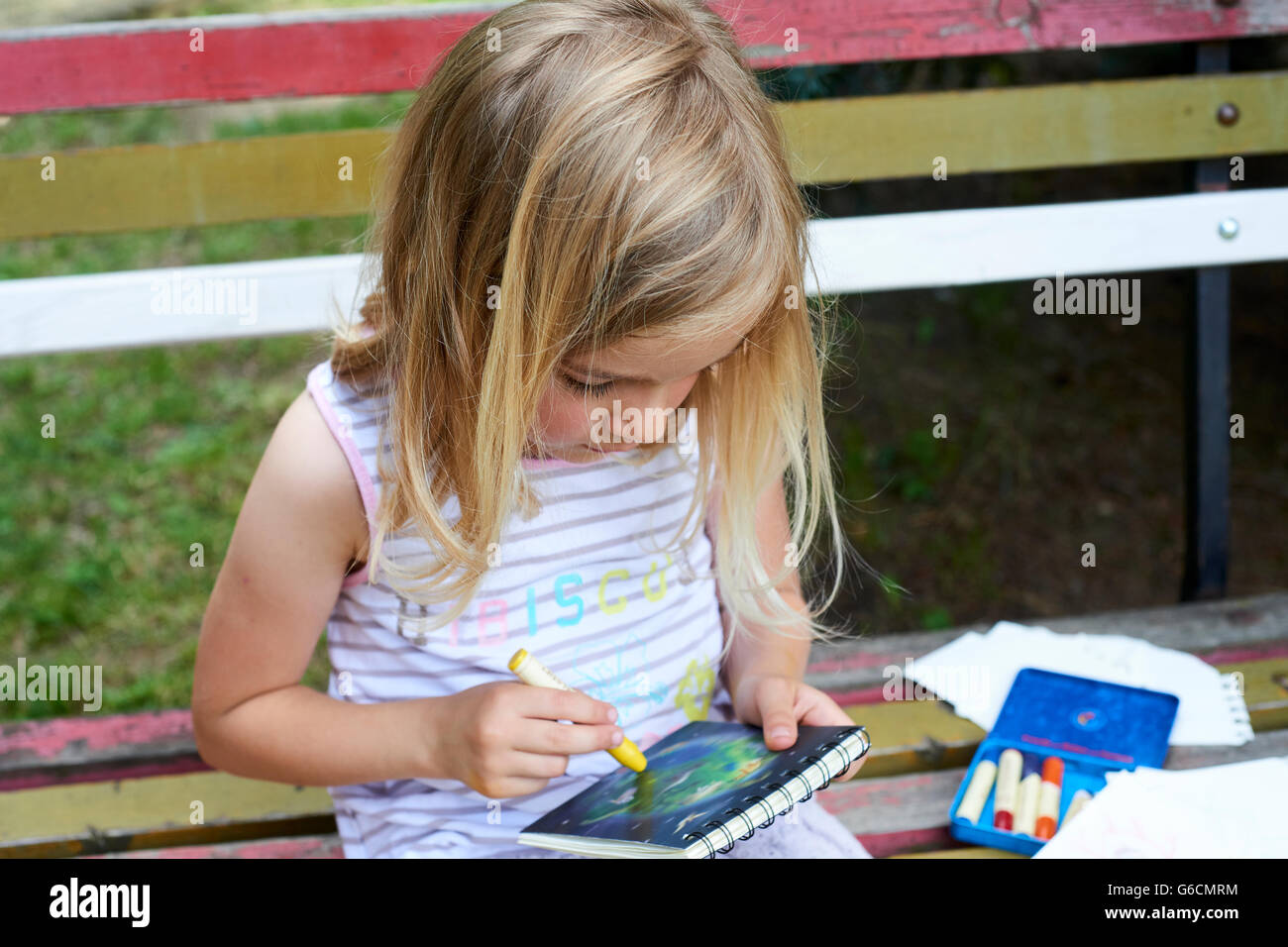 Schöne kaukasischen Blondine sitzt auf alten Parkbank Bild zeichnen Stockfoto