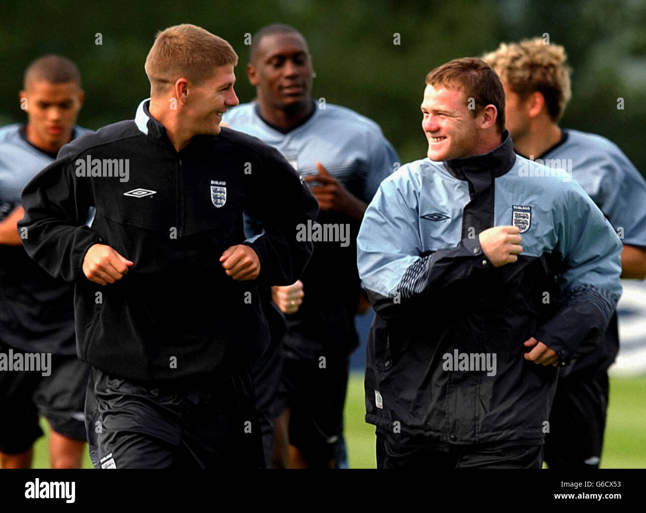 Die englischen Spieler Wayne Rooney (rechts) und Steven Gerrard (links) teilen sich einen Witz während eines Mannschaftstrainings in Champney's Springs, Leicestershire, um sich auf Englands internationales Freundschaftsspiel gegen Serbien-Montenegro im Walkers Stadium von Leicester City am Dienstag vorzubereiten. Stockfoto