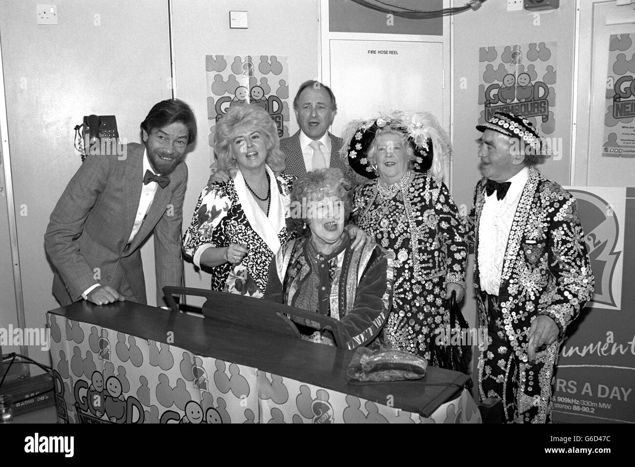 EastEnders Schauspielerin Anna Wing spielt Klavier, mit stimmlicher Unterstützung von Radio 2 Moderatoren (l-r) Adrian Love, Gloria Hunniford und David Jacobs, sowie Pearly King und Queen Joe und Kitty Davies, während einer Sondersendung von der Spitze des BT-Turms in London. Die Show war der Höhepunkt der BBC-Kampagne für gute Nachbarn, die die Taten der Freundlichkeit und des guten Willens der Menschen in Großbritannien hervorhob. Stockfoto