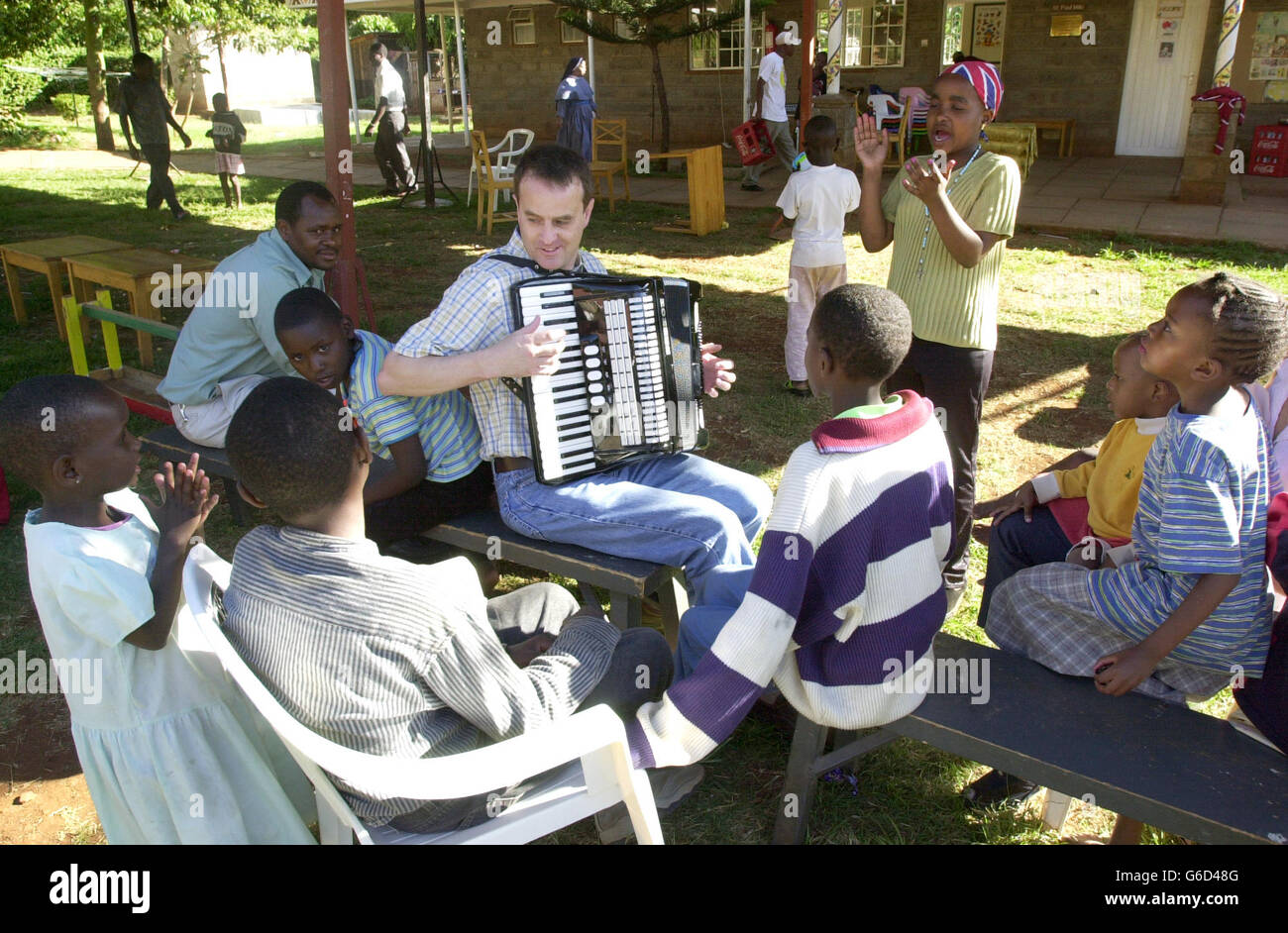 Pilot Simon Wood aus Barnett, London, wechselt seine Fluginstrumente in ein musikalisches, während er während einer Osterparty in einem Waisenhaus in Nairobi, Kenia, ein HIV-positives Waisenkind unterhält. Simon, der als Senior First Officer bei British Airways arbeitet, war einer von 20 Mitarbeitern der Fluggesellschaft, die im Nyumbani-Waisenhaus eine Osterparty für 79 Kleinkinder veranstalteten. Das in Nairobi ansässige Waisenhaus kümmert sich nur um HIV-positive Waisen, die entweder ihre Eltern an AIDS verloren haben oder allein zur Selbsthilfe und Bekämpfung der Krankheit verlassen wurden. Stockfoto
