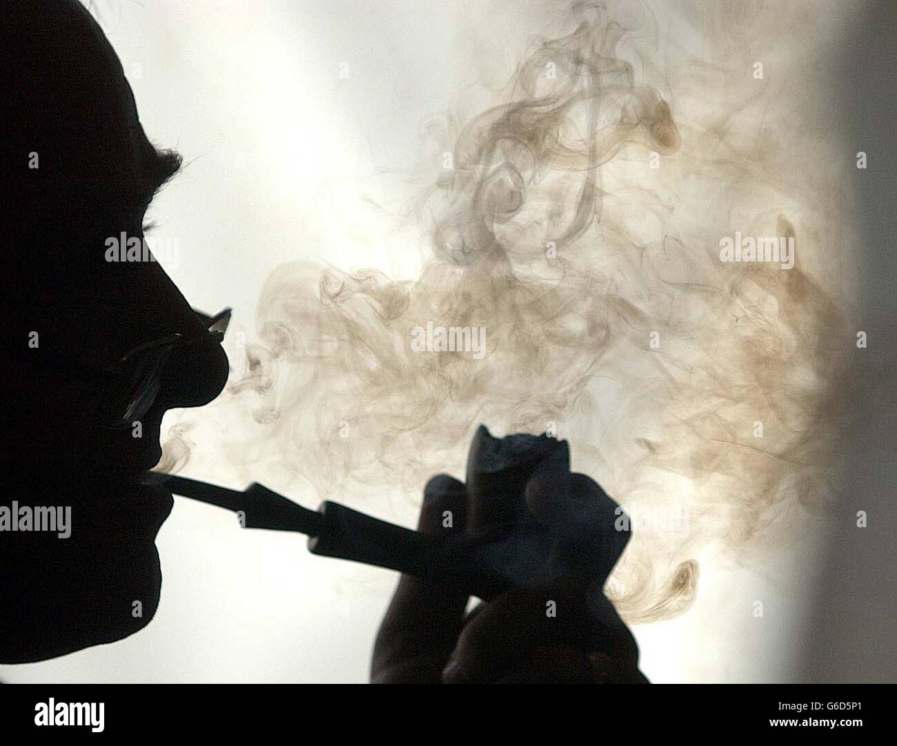 Ein Pfeifenraucherin konzentriert sich intensiv während der British Pipe Smoking Championships. Raucher hofften, den britischen Rekord von 2 Stunden 5 Minuten zu brechen, weil sie eine Pfeife am Turnierplatz im Old Silhilians Rugby and Cricket Club in Knowle, nahe Solihull, West Midlands, angezündet hatten. Stockfoto