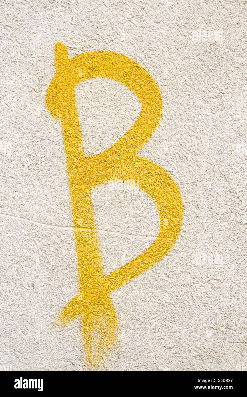 Graffiti aus einem gelben Buchstaben B auf einer Wand in Arezzo, Italien gesprüht. Stockfoto