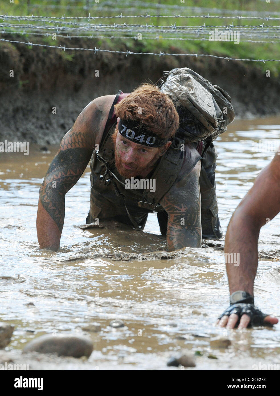 Lance Bombardier James Simpson, ein Doppelamputierte, taucht während des Spartan Race in Ripon, North Yorkshire, über ein brennendes Hindernis. Stockfoto Lance Bombardier James Simpson, ein Doppelamputierte, taucht während des Spartan Race in Ripon, North Yorkshire, über ein brennendes Hindernis. Stockfoto