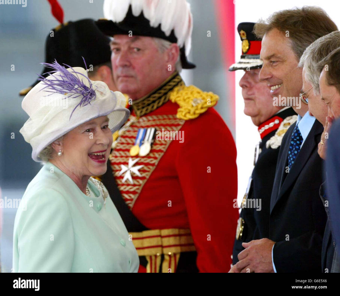 Königin Elizabeth II lacht mit Premierminister Tony Blair (3. Rechts), als sie und der russische Präsident Wladimir Putin (nicht abgebildet) am ersten Tag seines Staatsbesuchs bei der Horse Guards Parade in London eintreffen. * Es ist der erste Staatsbesuch eines russischen Führers seit den Tagen der Zaren. Stockfoto