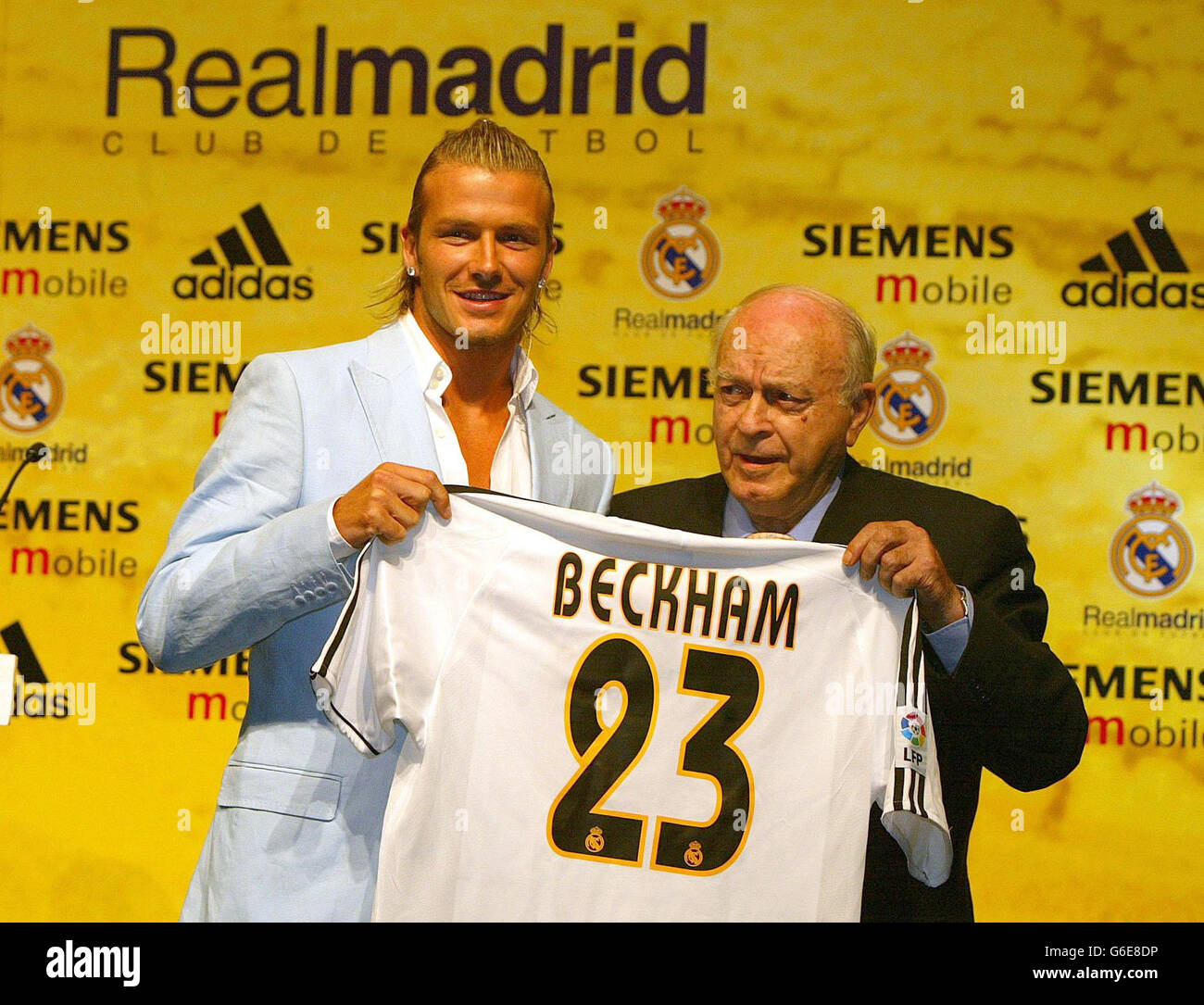 David Beckham (links) hält sein neues Real Madrid Trikot mit der Nummer 23, das ihm der Ehrenpräsident und ehemalige Spieler Alfredo Di Stefano überreicht hat, als er offiziell im Basketballstadion neben dem Trainingsgelände des Clubs in Madrid vorgestellt wird. Stockfoto