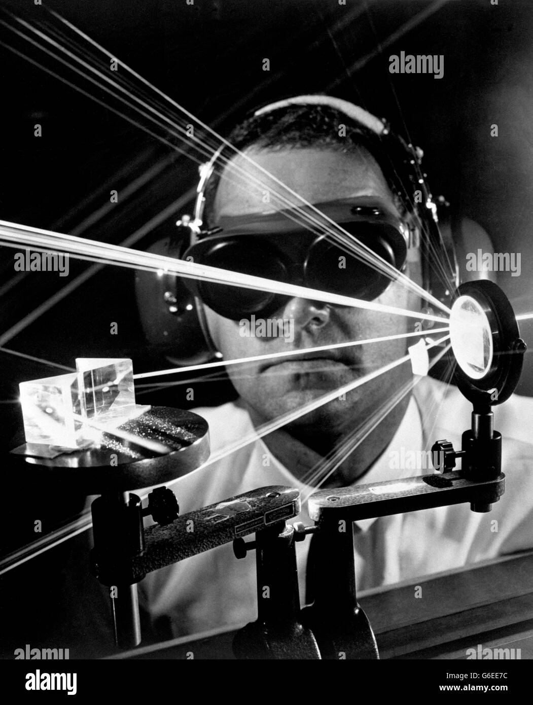 Strahlen eines Gaslaserstreifens im Suchlichtfeld passieren die geschützten Augen des Betreibers Dr. A Stevens Halsted in den Labors der Hughes Aircraft Company in Amerika, wo das Gerät erfunden wurde. Der Dauerwellen-Argon-Ionen-Laser mit einer Leistung von bis zu acht Watt arbeitet bei verschiedenen Wellenlängen im blau-grünen Bereich des sichtbaren Spektrums. Stockfoto