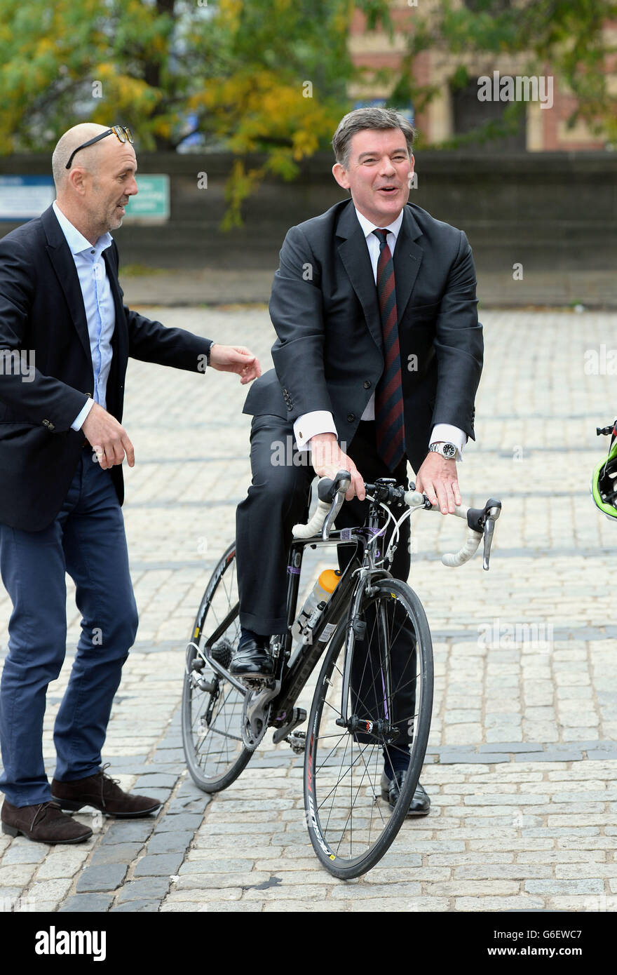 Der Sportminister Hugh Robertson testet bei einer Fotozelle im Rathaus von Leeds ein Rennrad. Der Minister besuchte Leeds und besuchte Personen, die an der Organisation des Grand DEPART der Tour de France beteiligt waren, der im kommenden Juli in der Stadt beginnt. Stockfoto