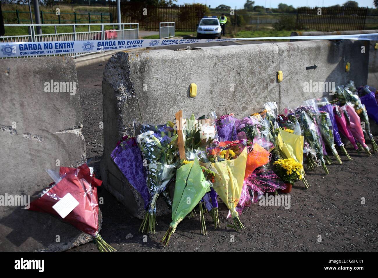 Blumen an der Stelle, an der eine Leiche in einem Feld am Rande von Nord-Dublin gefunden wurde, die vermutlich die des vermissten Rentners Peggy Mangan war, wurden von der Polizei in der Nähe des Ikea-Komplexes in Ballymun gefunden. Stockfoto