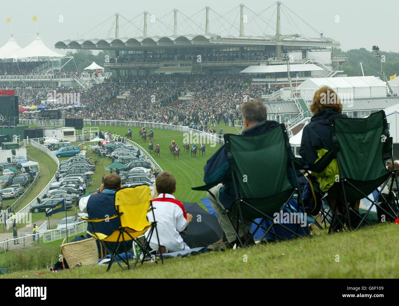 Rennfahrer auf Trundle Hill beobachten die Oak Tree Stakes auf der Goodwood-Rennbahn in der Nähe von Chichester, West Sussex. Das normalerweise „glorreiche Goodwood“-Treffen wurde die ganze Woche über von schlechtem Wetter und Regenschauern heimgesucht. Stockfoto