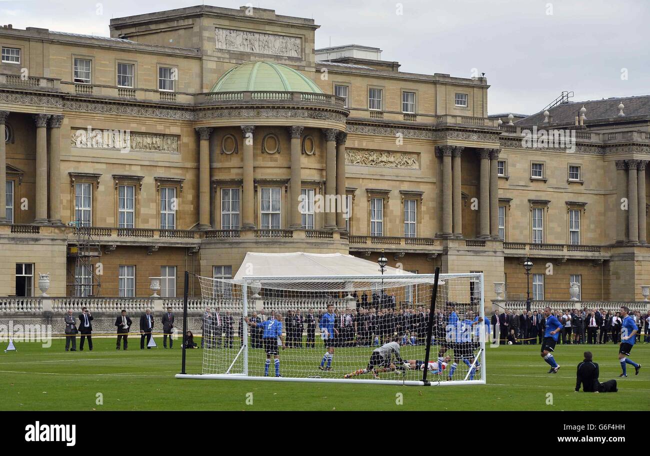 Polytechnic FC (in blau), während ihres Spiels mit dem Civil Service FC im Garten des Buckingham Palace im Zentrum von London. Stockfoto