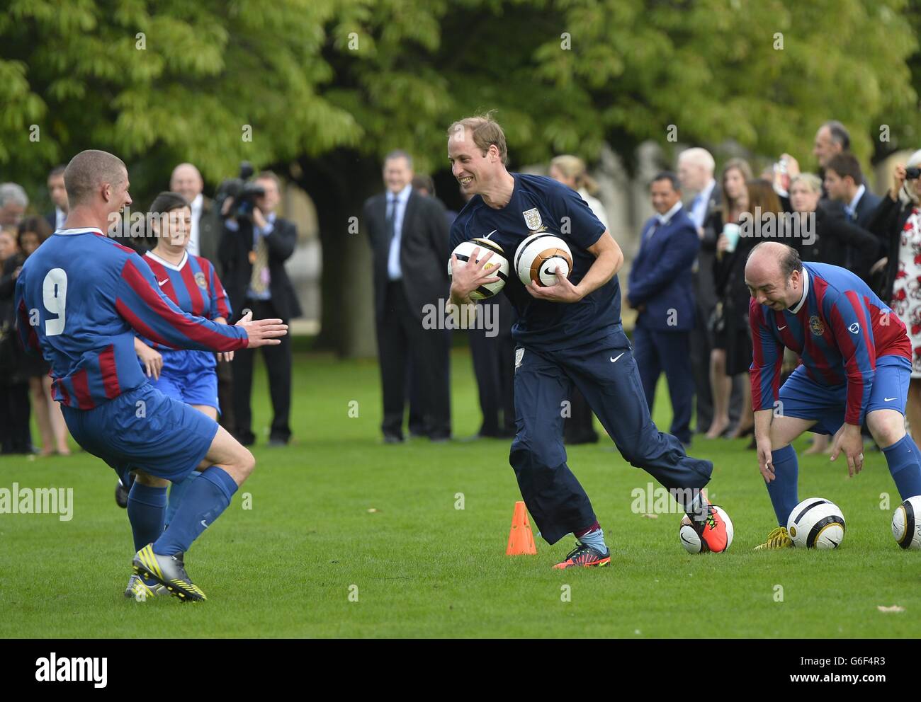 Der Duke of Cambridge trainiert mit Mitgliedern des Royal Household während der zweiten Hälfte eines Spiels zwischen dem Polytechnic FC und dem Civil Service FC, auf dem Gelände des Buckingham Palace's Garden, im Zentrum von London. Stockfoto