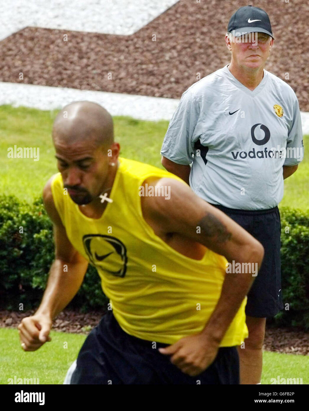 Manchester United Manager Sir Alex Ferguson beobachtet Juan Sebastian Veron (unten) während des Trainings vor dem Vorsaison-Freundschaftsspiel gegen Juventus auf dem Rutgers Campus Football Ground, New Jersey Stockfoto