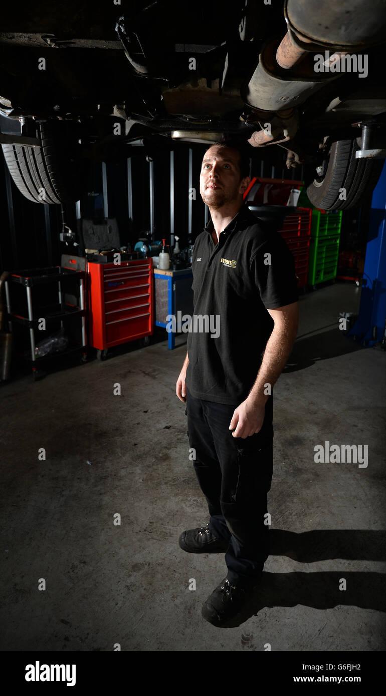 Ein Mechaniker überprüft die Unterseite eines Bentley-Fahrzeugs Stockfoto
