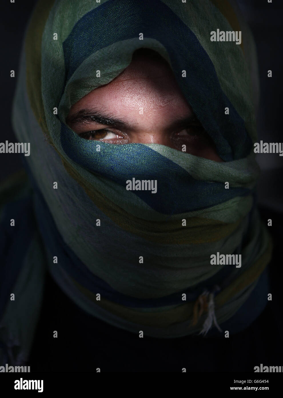 Ein syrischer Flüchtling, der nur als Nidal benannt wurde, sein Gesicht verhüllt, um seine Identität zu schützen, der einen Angriff überlebte, bei dem sein Cousin und drei Nachbarn getötet wurden, als er in einem Caritas-Gemeinschaftszentrum in Amman, Jordanien, 24/10/2013, medizinische Versorgung erhält. Stockfoto