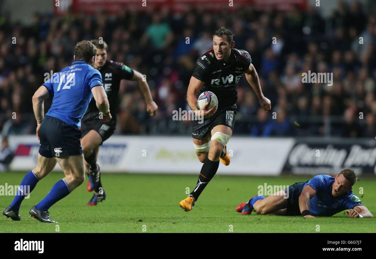 Joe Bearman von ospreys läuft beim Heineken Cup-Spiel im Liberty Stadium, Swansea, an der Herausforderung von Leinster's Jimmy Gopperth und bei Gordon D'Arcy (12) vorbei. Stockfoto