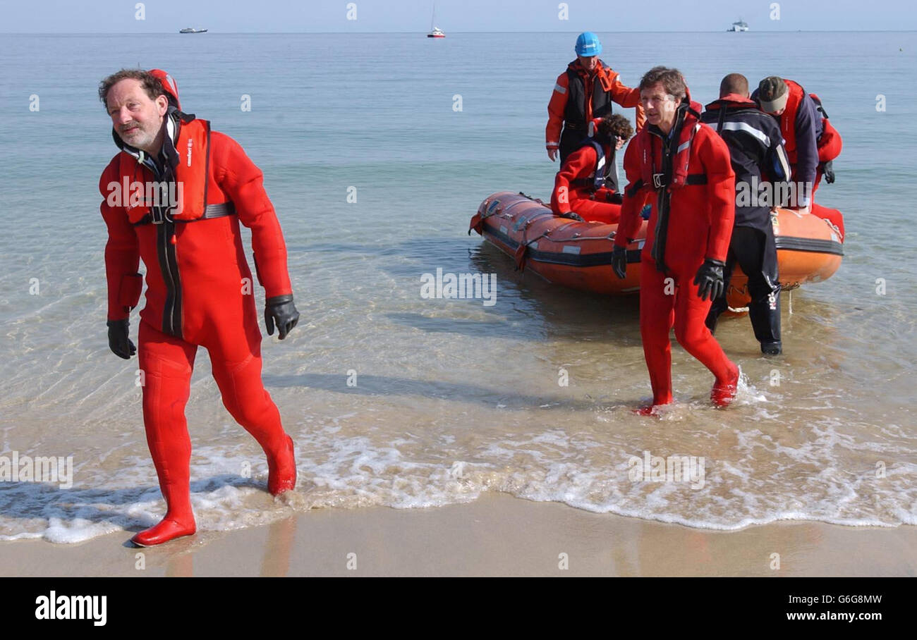 Die Piloten Andy Elson (links) und Colin Prescot (rechts) kehren nach ihrem abgebrochenen Versuch, einen historischen Flug an den Rand des Weltraums im riesigen 1,270m hohen QinetiQ1-Ballon zu machen, zum Carbis Bay Beach in St.Ives, Cornwall zurück. Der Versuch wurde abgebrochen, nachdem ein Loch im Ballon gefunden wurde, als er an Bord des Trimaran-Kriegsschiffes Triton aufgeblasen wurde. Sie hatten gehofft, einen 40 Jahre alten Höhenrekord zu schlagen und im Ballon eine Höhe von mehr als 25 Meilen zu erreichen. Stockfoto