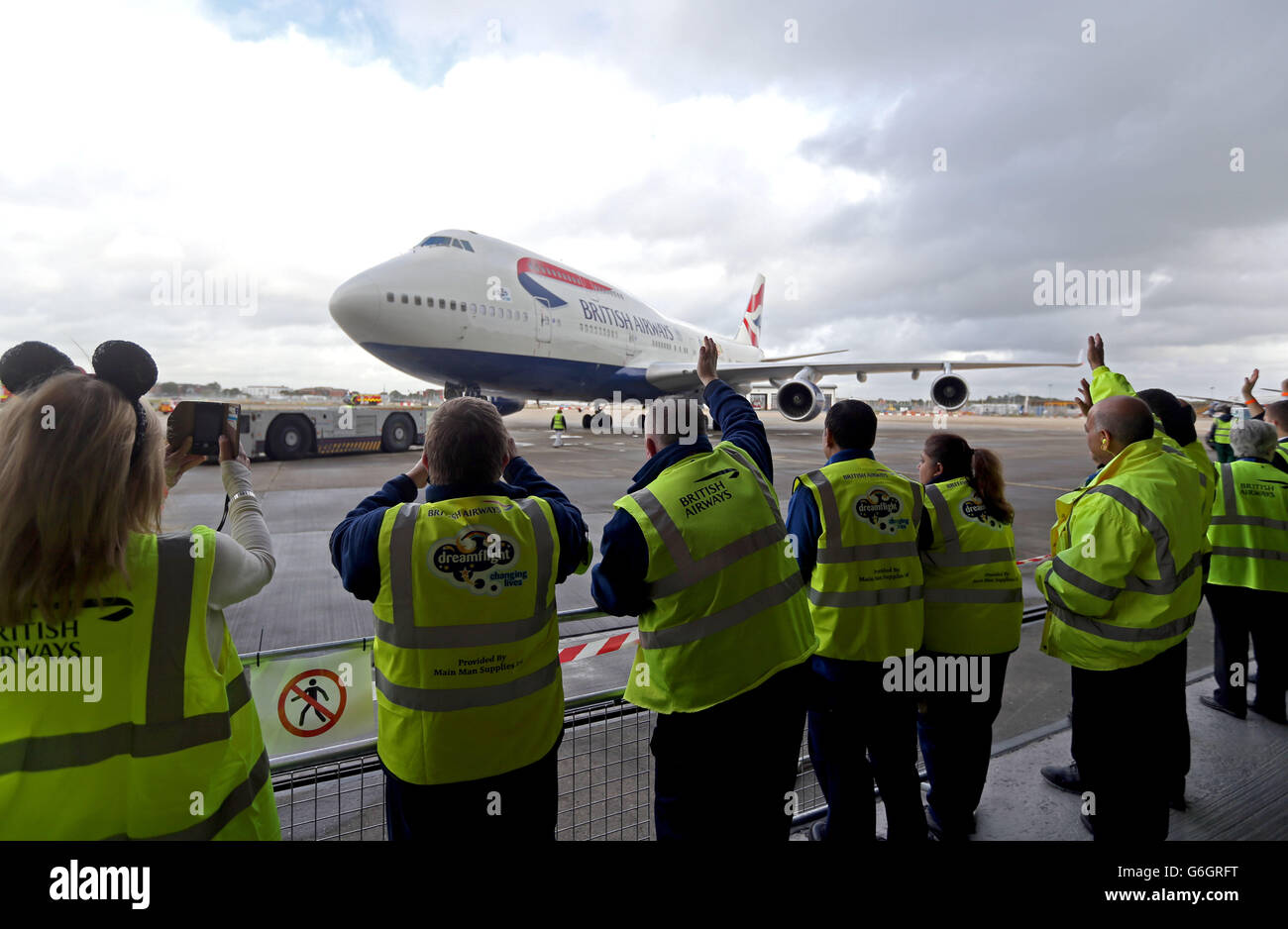 Mitarbeiter winken aus dem British Airways Dreamflight-Flugzeug, bevor es nach Florida, USA, fliegt. Stockfoto