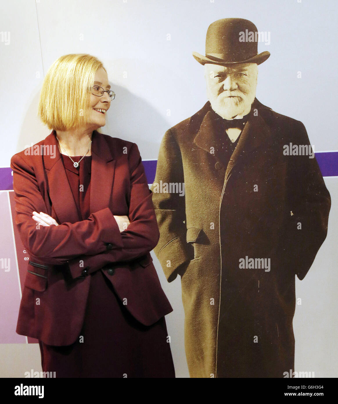 Holyrood Präsidialbeamter Tricia Marwick mit einem Foto von Andrew Carnegie während der Eröffnung der Ausstellung Andrew Carnegie: The Legacy That Changed the World, die heute im schottischen Parlament in Edinburgh eröffnet wurde. Stockfoto