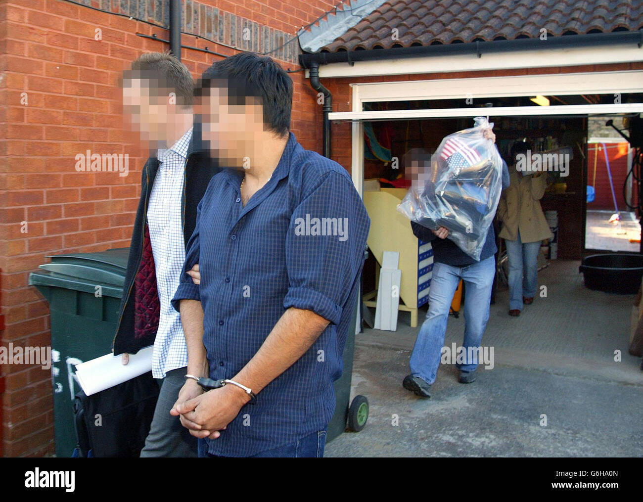 Polizeibeamte eskortieren einen verhafteten Mann und tragen Beweise nach einer Hausdurchsuchung im Morgengrauen auf einem Grundstück im Osten Londons mit sich. Scotland Yard gab später bekannt, dass sie während einer Reihe koordinierter Razzien in der Hauptstadt eine große internationale Drogen- und Geldwäsche-Operation zerschlagen haben. Die Razzien - 23 in London und bis zu 25 in Kolumbien - waren die letzte Phase einer zweijährigen Operation gegen den größten Kokain-Import- und Geldwäschering, der jemals im Vereinigten Königreich entdeckt wurde. Stockfoto