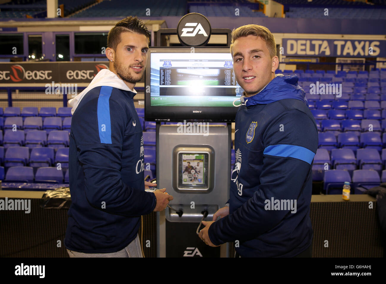 Die Everton-Spieler Kevin Mirallas und Gerard Deulofeu spielen FIFA-Spiel vor Everton-Fans, die im Goodison Park auf einem großen Bildschirm sehen können Stockfoto